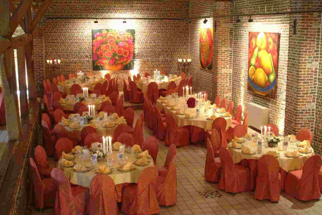 Elegant banquet hall with orange tablecloths, ideal for weddings and corporate events.