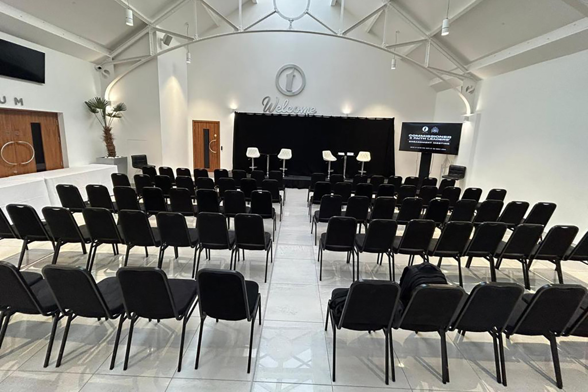 Modern event space in The Atrium, featuring black chairs and a sleek stage for conferences.