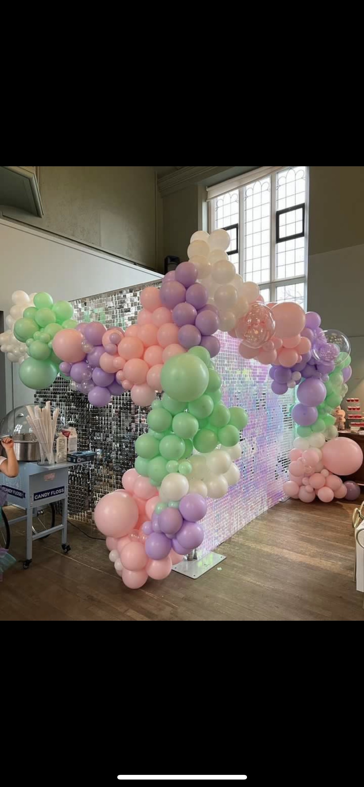 Vibrant pastel balloon arch at Refettorio Felix, ideal for festive celebrations.