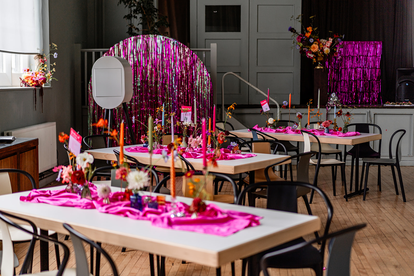 Vibrant event space at Refettorio Felix with pink decor for a festive celebration.