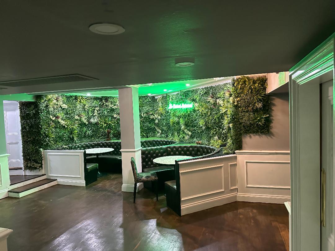 Stylish event space at The Calabash Restaurant with lush greenery and circular seating.