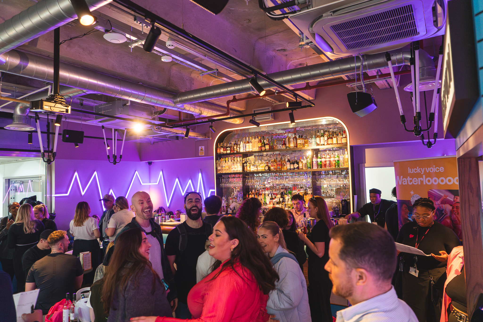 Vibrant networking event at Lucky Voice Waterloo with stylish bar and diverse attendees.