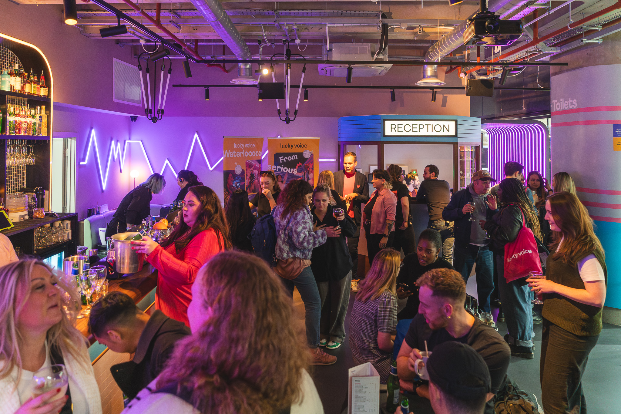 Christmas party at Lucky Voice Waterloo with vibrant networking and colorful lighting.