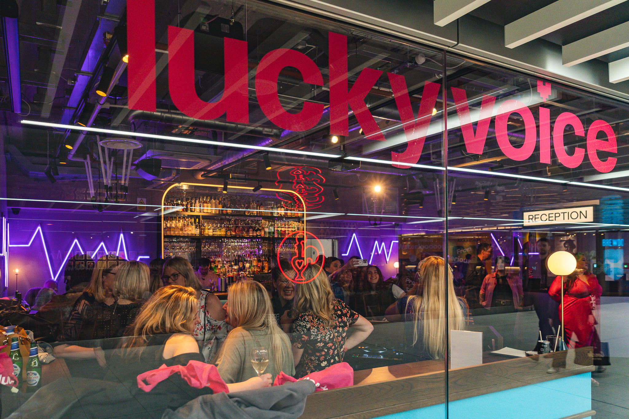 Christmas party at Lucky Voice Waterloo with vibrant neon lights, ideal for corporate events.