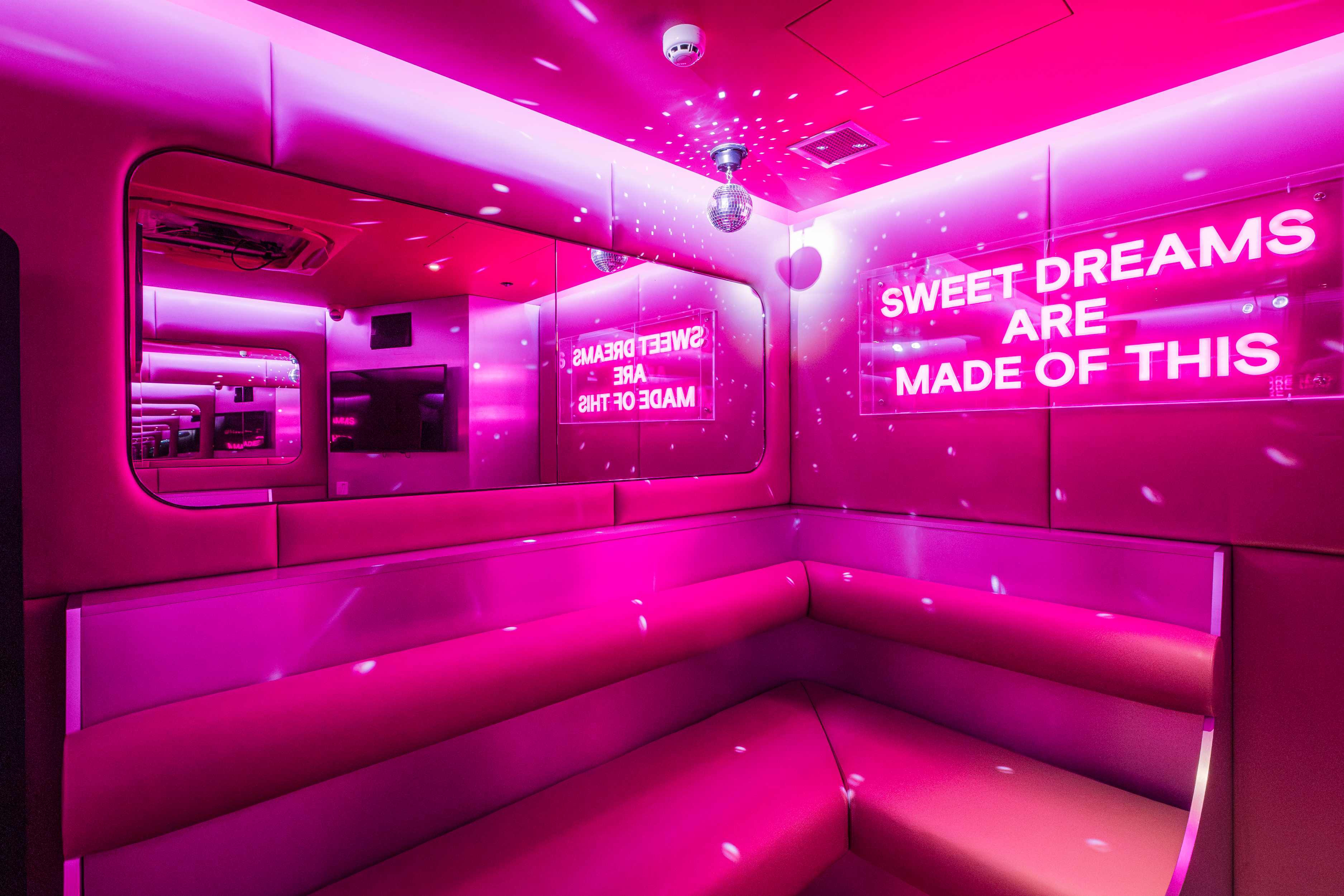 "Vibrant pink-lit lounge at Lucky Voice Waterloo for summer parties and networking events."