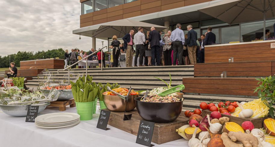 Outdoor networking event at Centrum with vibrant buffet and fresh salads.