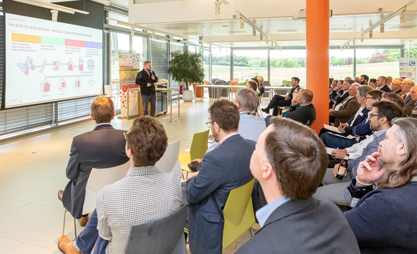 Corporate presentation in modern venue with engaged audience and visual aids.