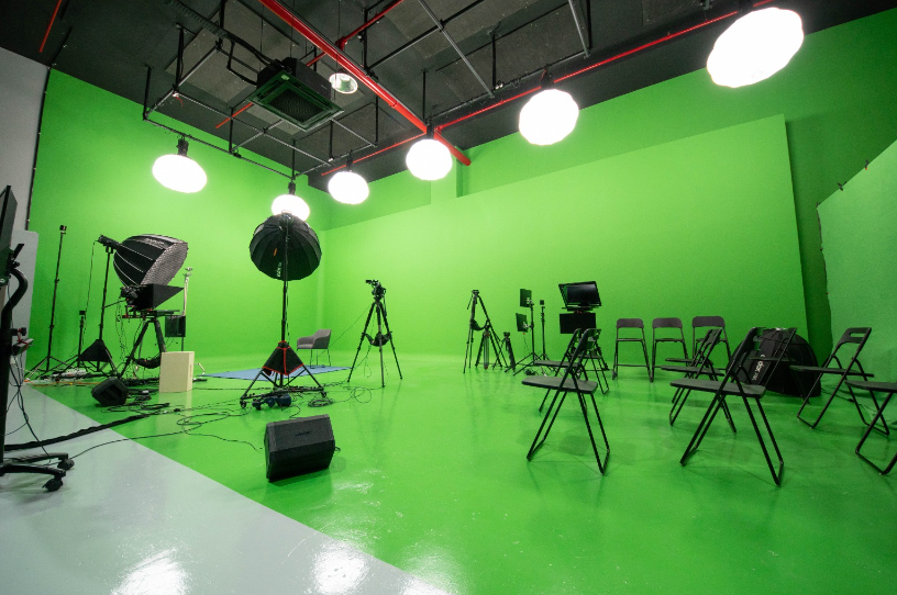 Versatile green screen studio for hybrid events with professional lighting and camera setup.