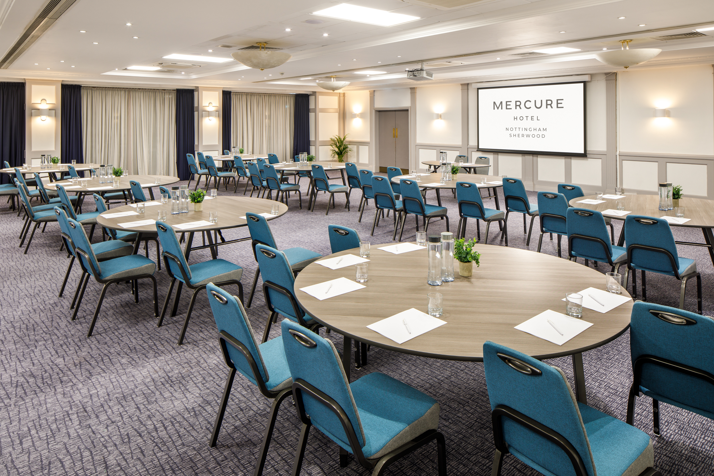 Regent Suite at Mercure Nottingham: modern meeting space with round tables for corporate events.