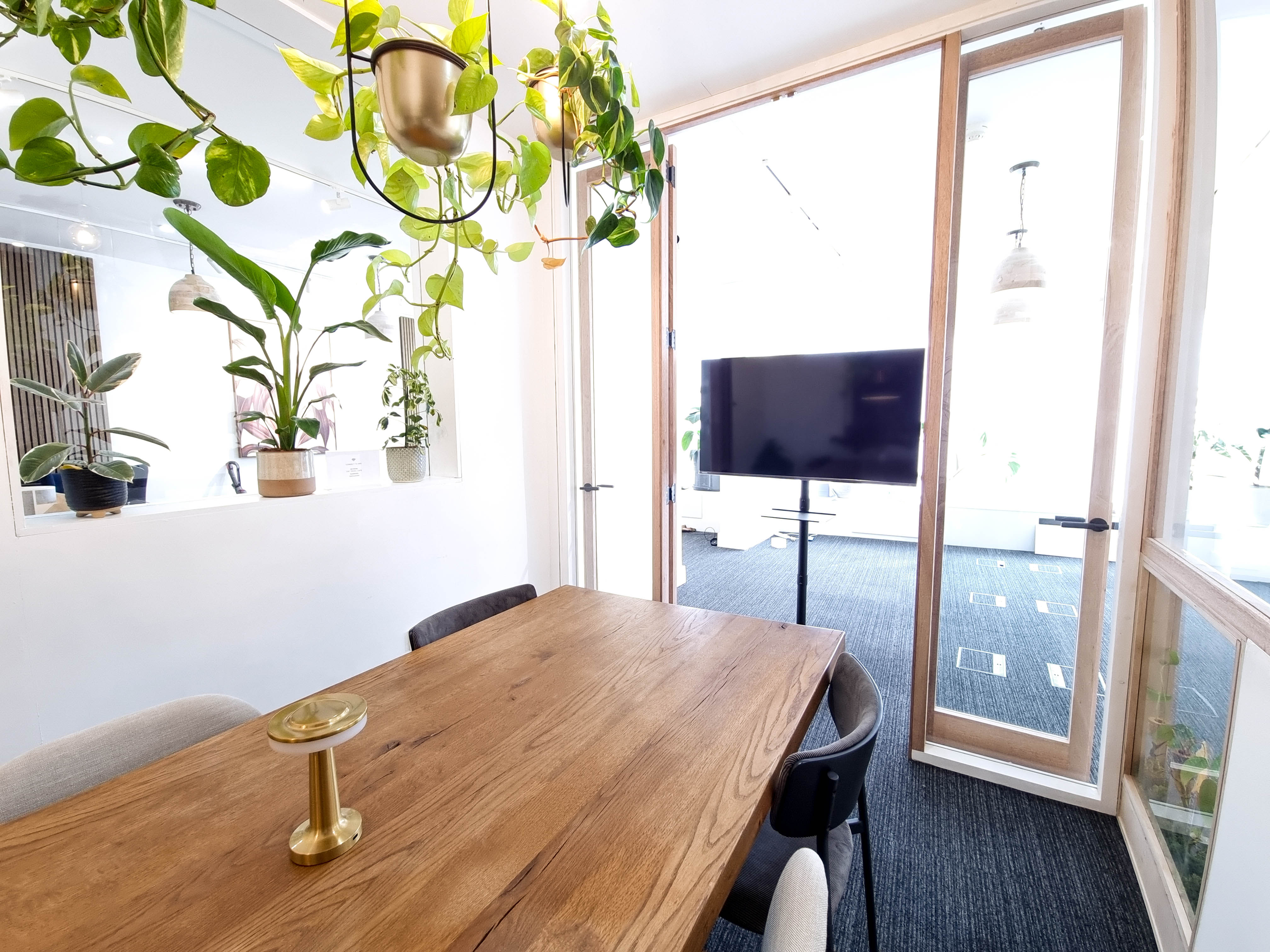 Bright modern meeting room with wooden table, ideal for events and presentations.