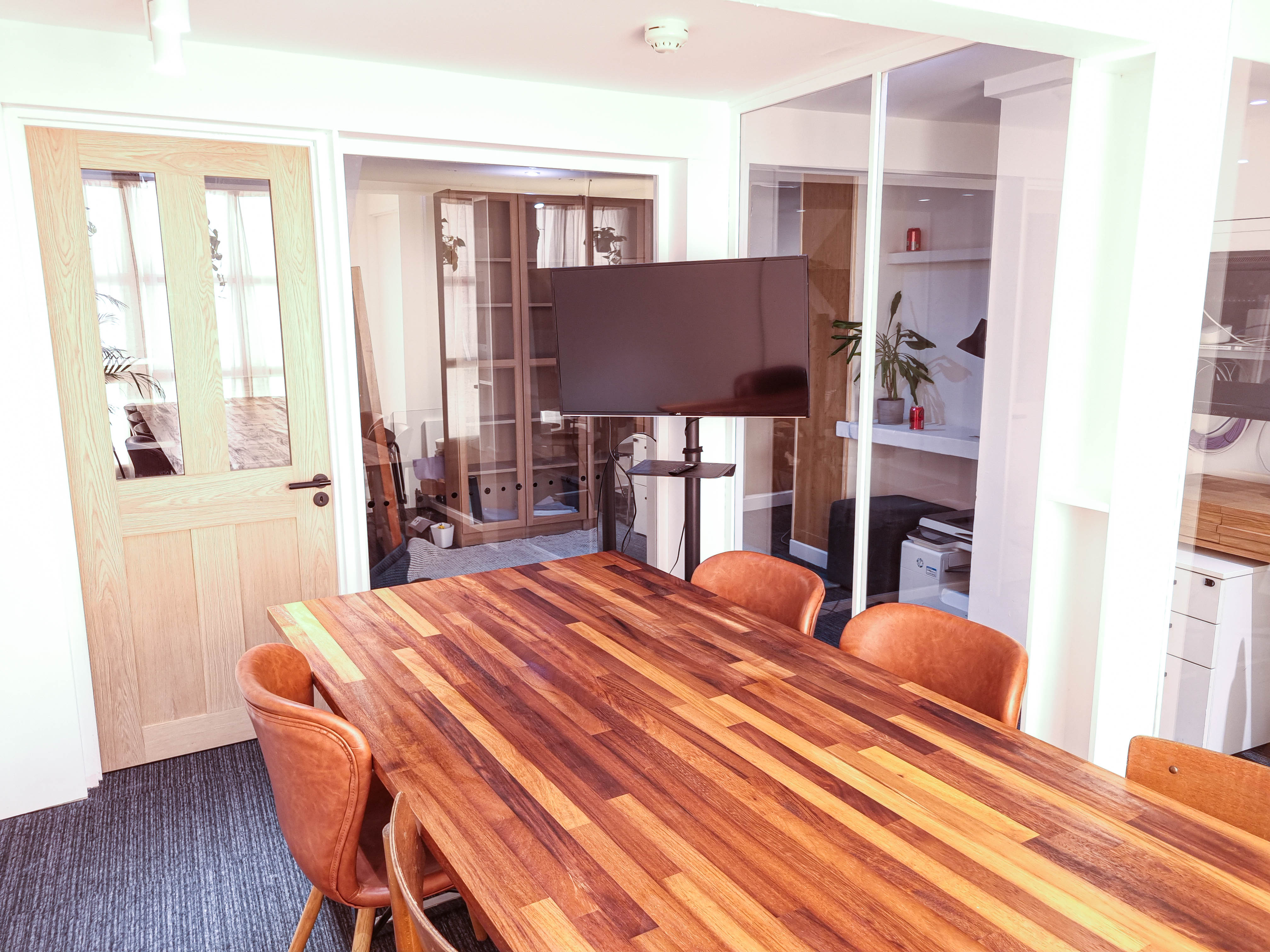 Modern meeting room with wooden table, ideal for presentations and brainstorming sessions.