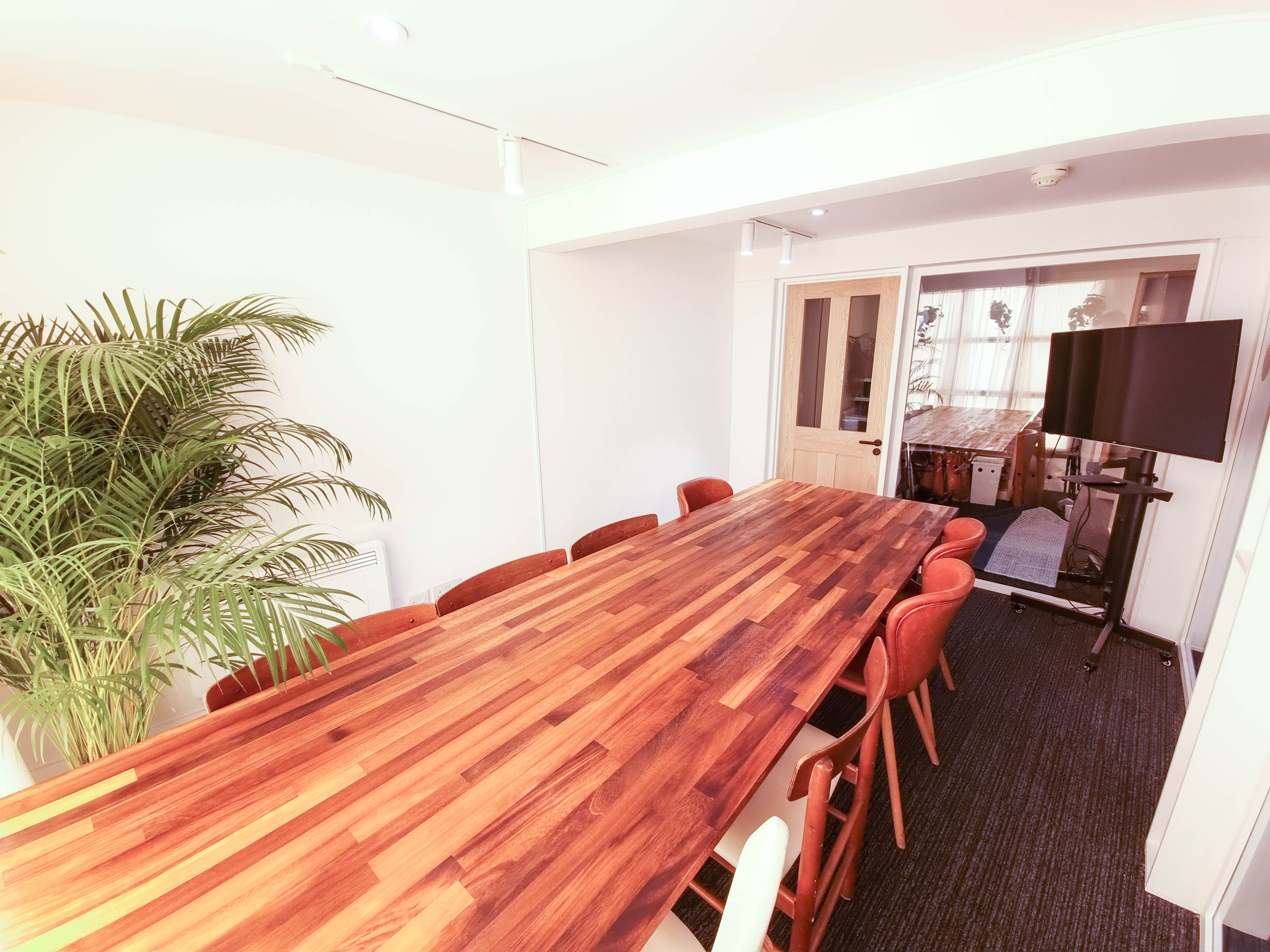 Modern meeting room with wooden table, ideal for presentations and brainstorming sessions.