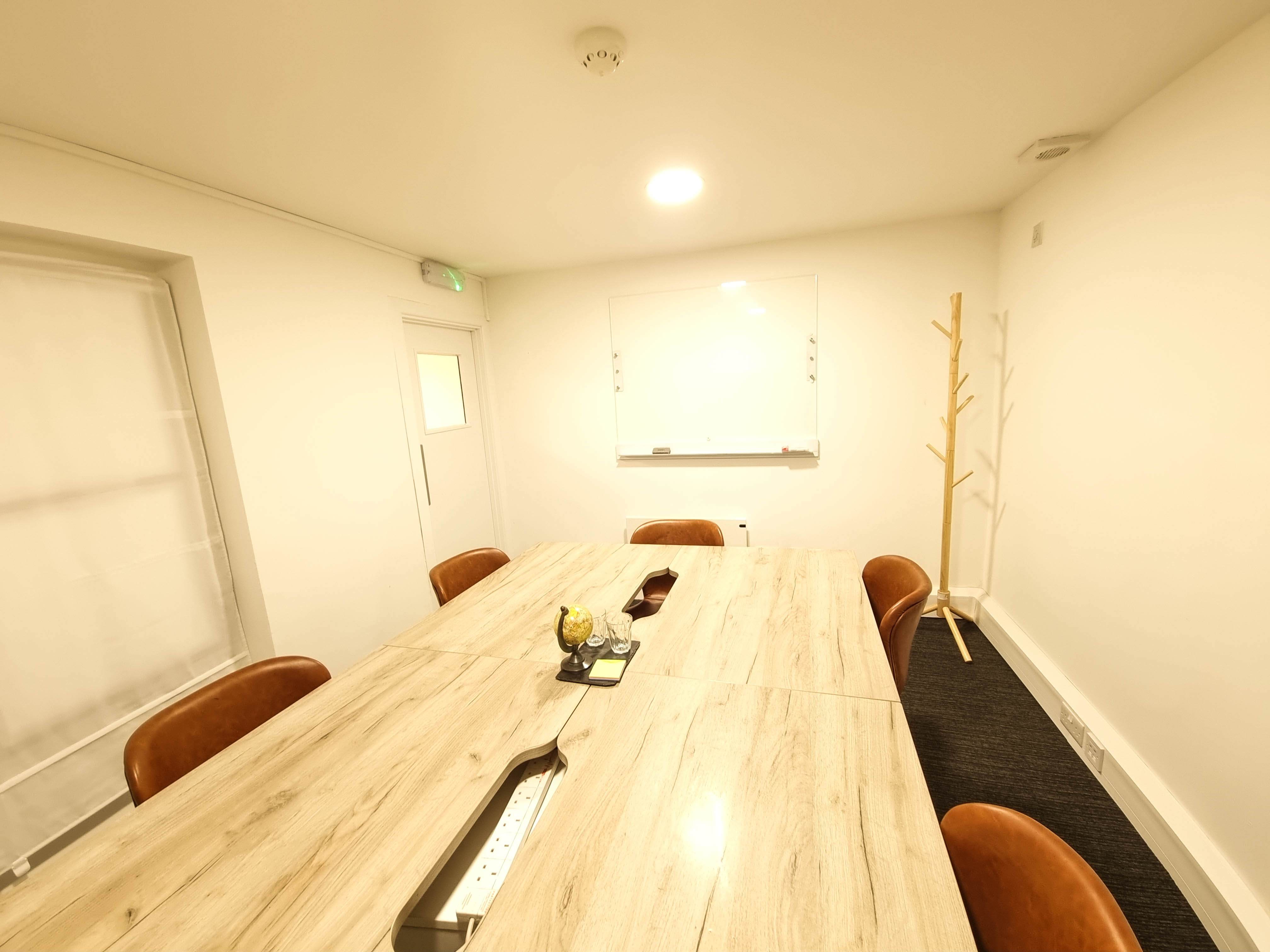 Modern meeting room with wooden table and leather chairs for strategic planning.