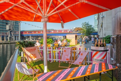 Vibrant Summer Terrace event space with colorful chairs by the water for social gatherings.