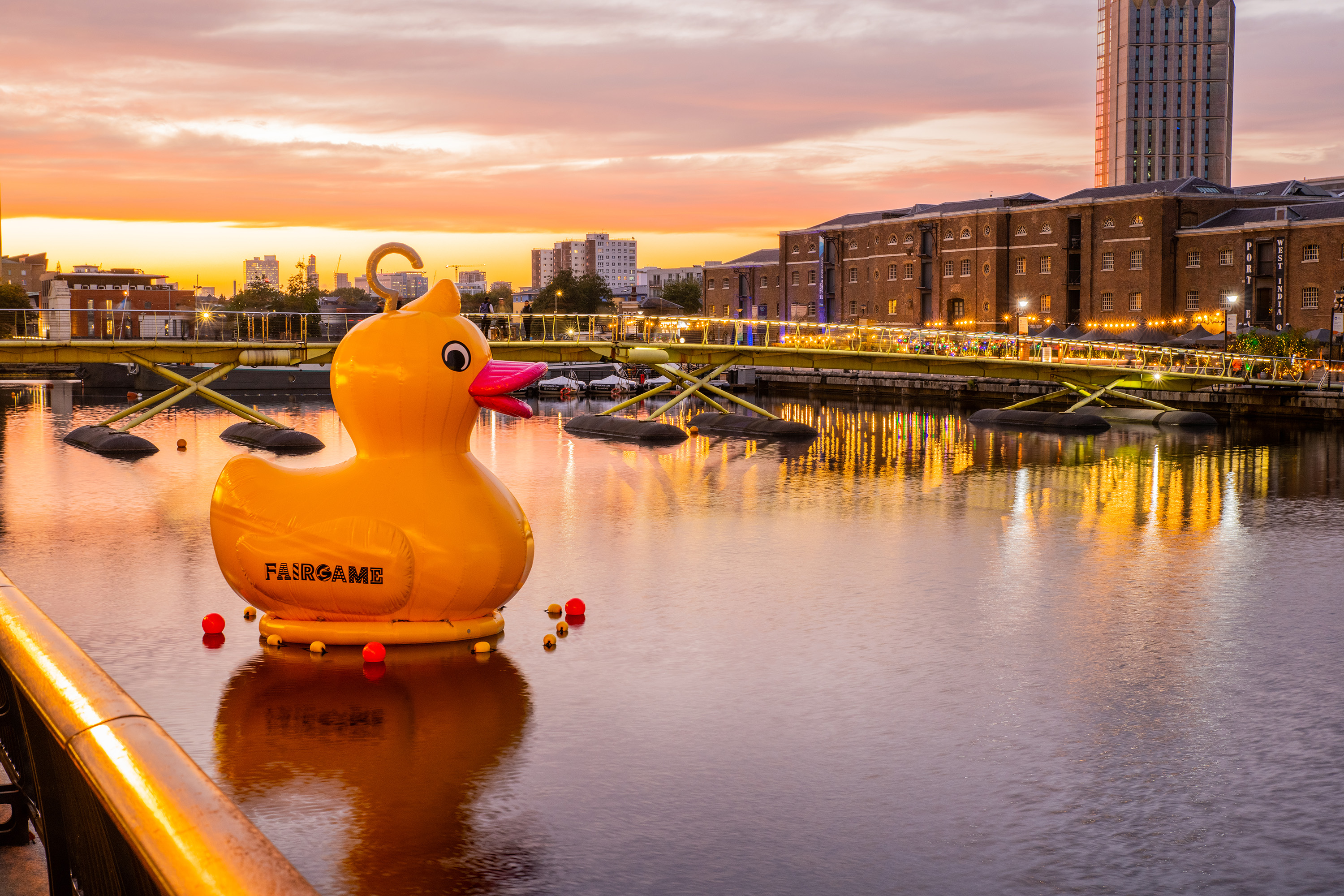 Vibrant sunset over waterfront with inflatable rubber duck for outdoor events and festivals.
