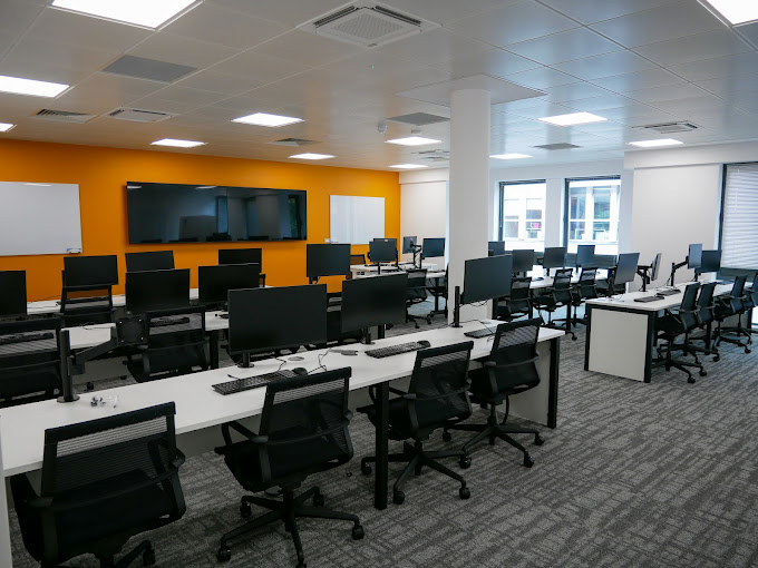 Modern training facility with workstations, ideal for tech workshops and team-building events.