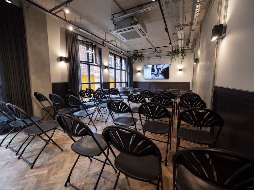 Versatile meeting space with black folding chairs, ideal for corporate events and presentations.