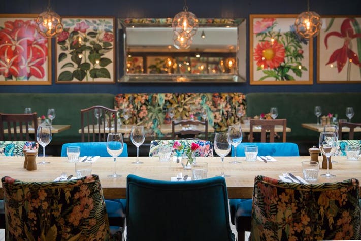 Vibrant dining room with floral decor for intimate gatherings and corporate events.