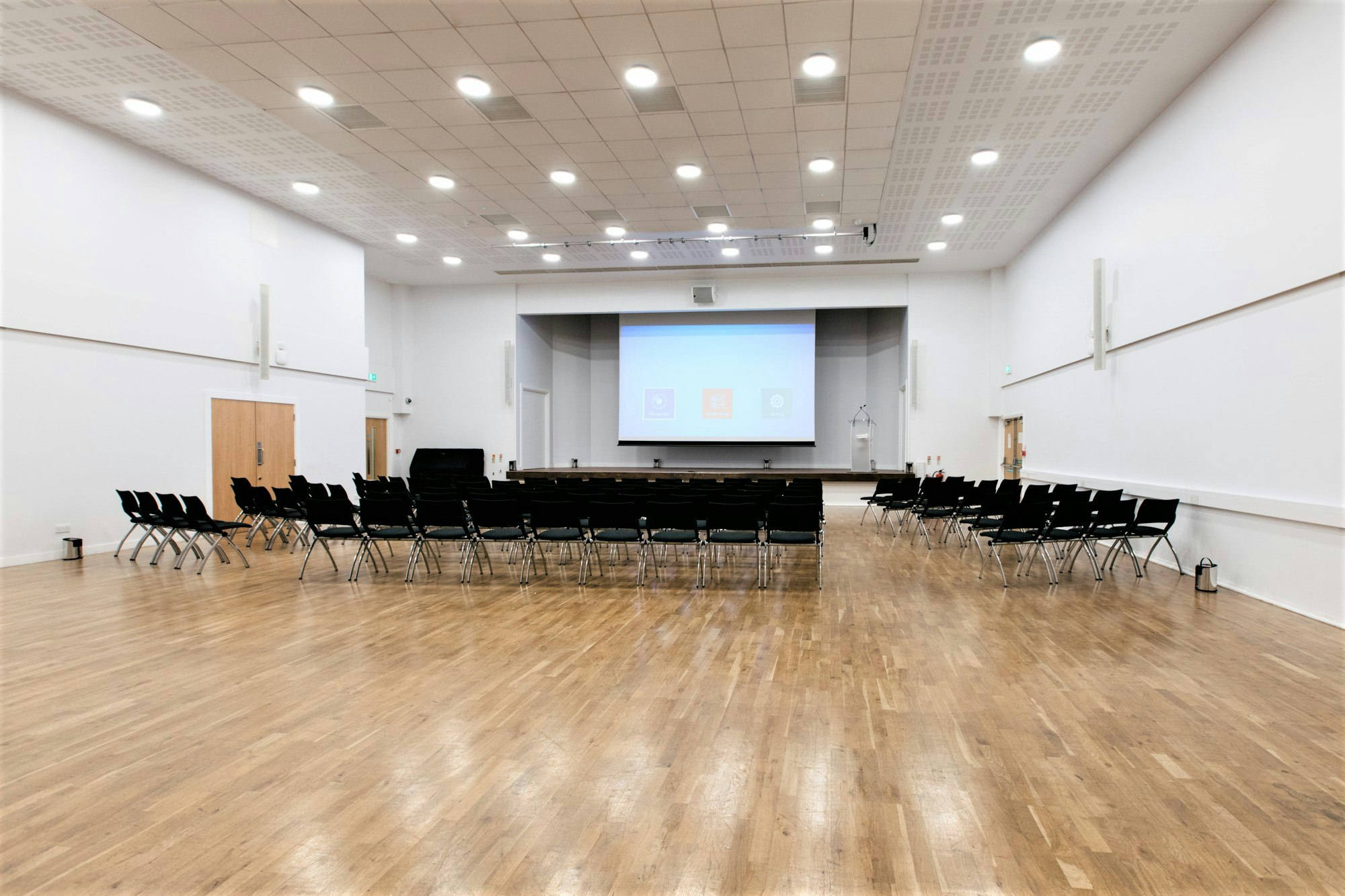 Spacious event hall with black chairs for seminars and workshops at MPW Queen's Gate House.
