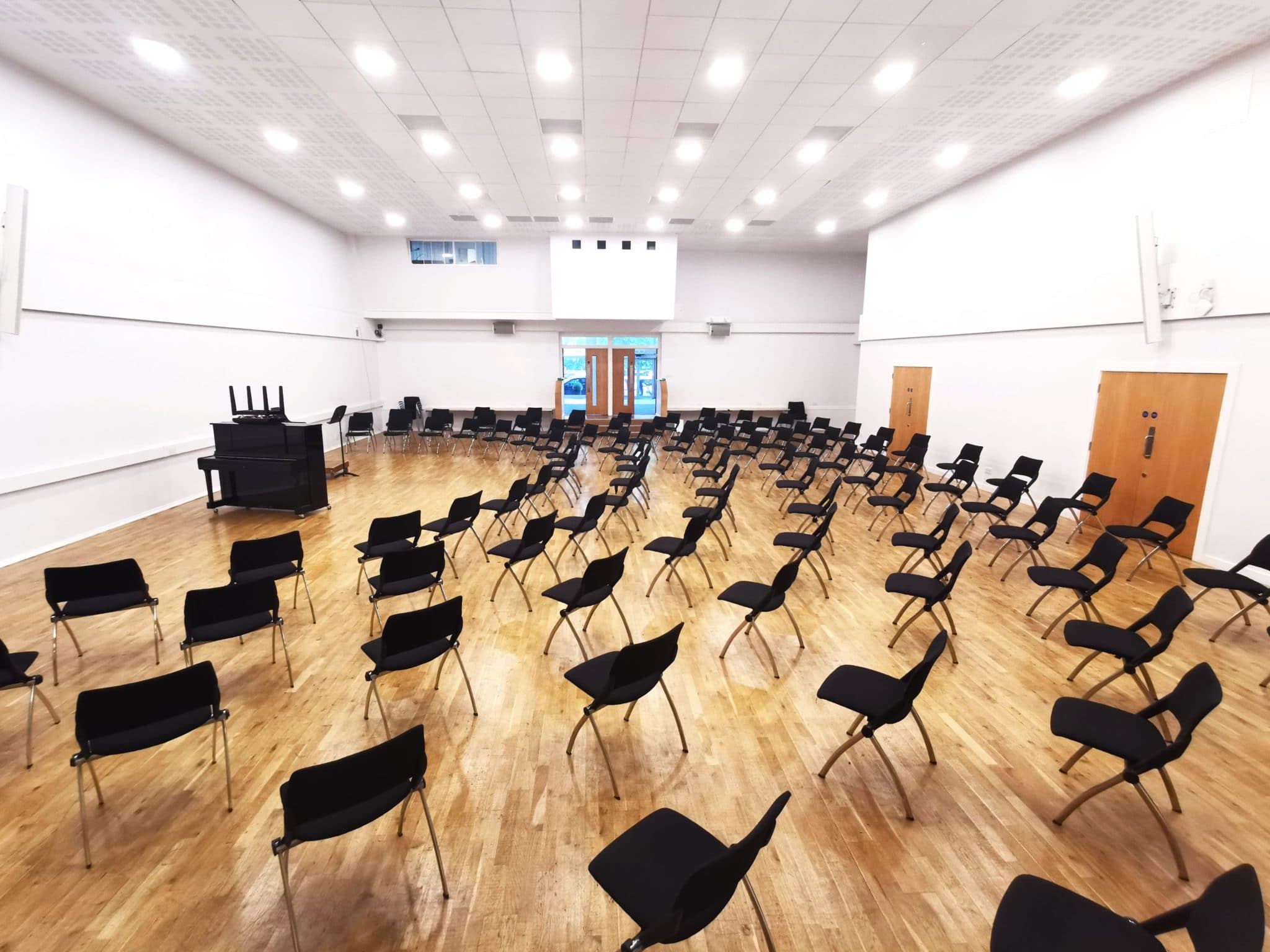 Spacious event hall with circular black chairs for interactive meetings and workshops.