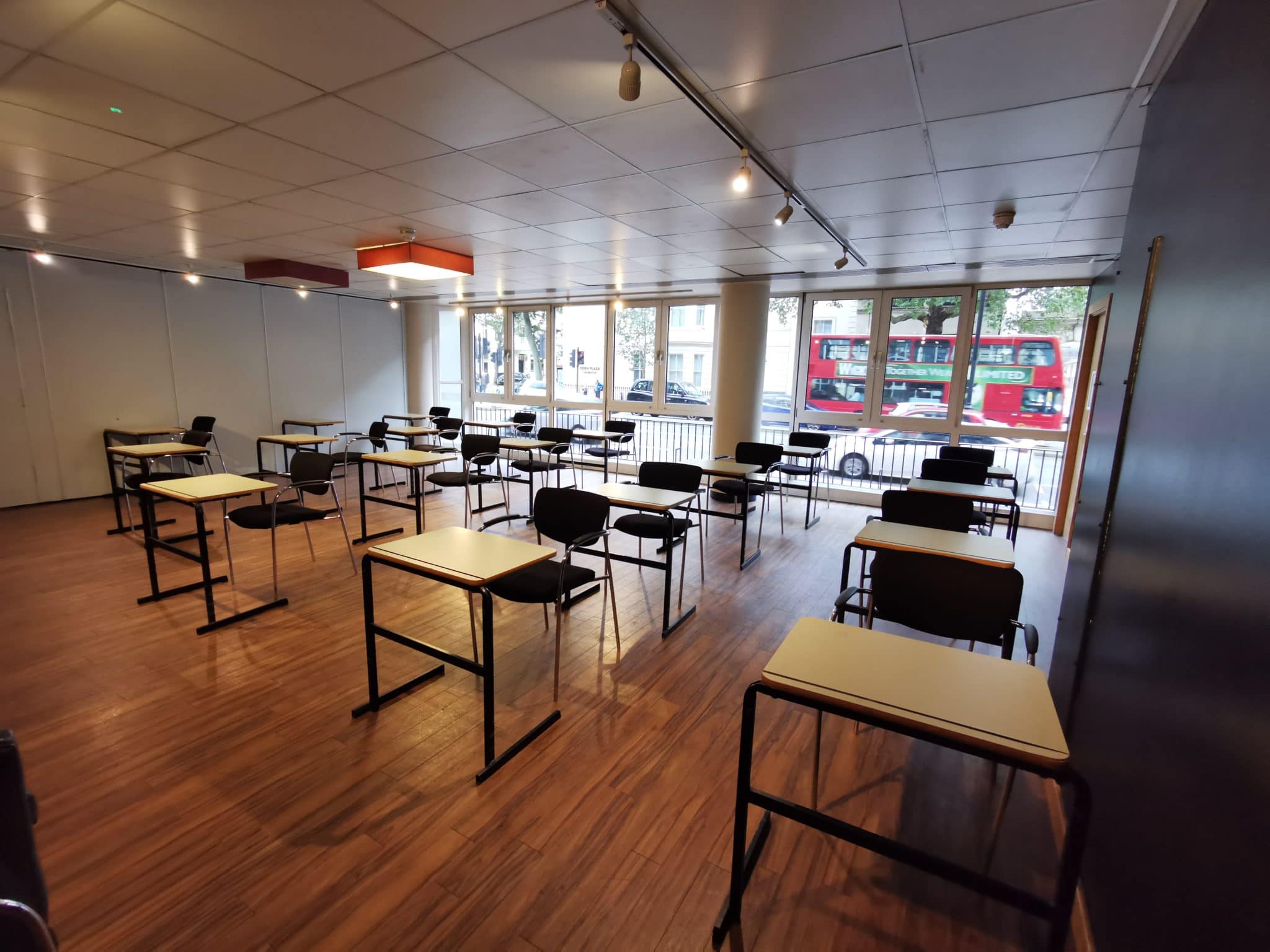 Versatile Event Hall with desks, ideal for workshops and training sessions.