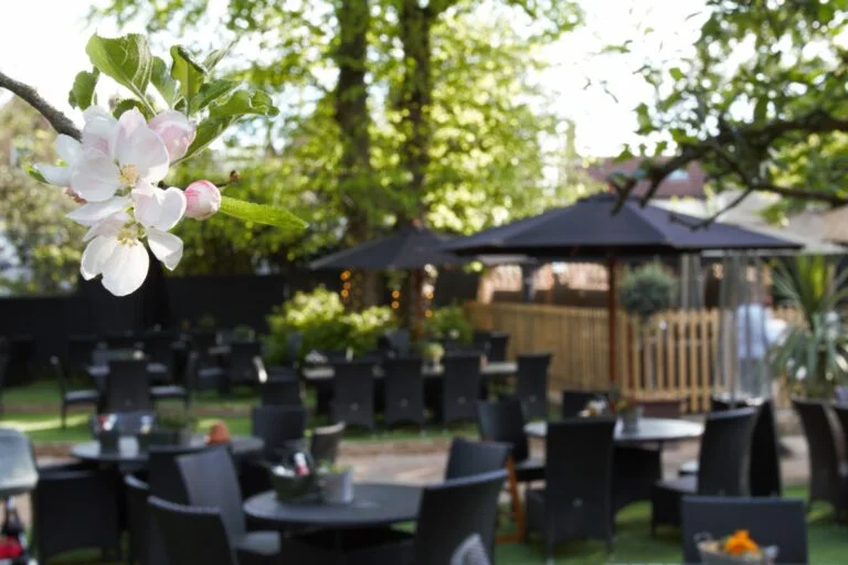 Elegant outdoor event space with lush greenery and blooming flowers at The Marlborough Richmond.