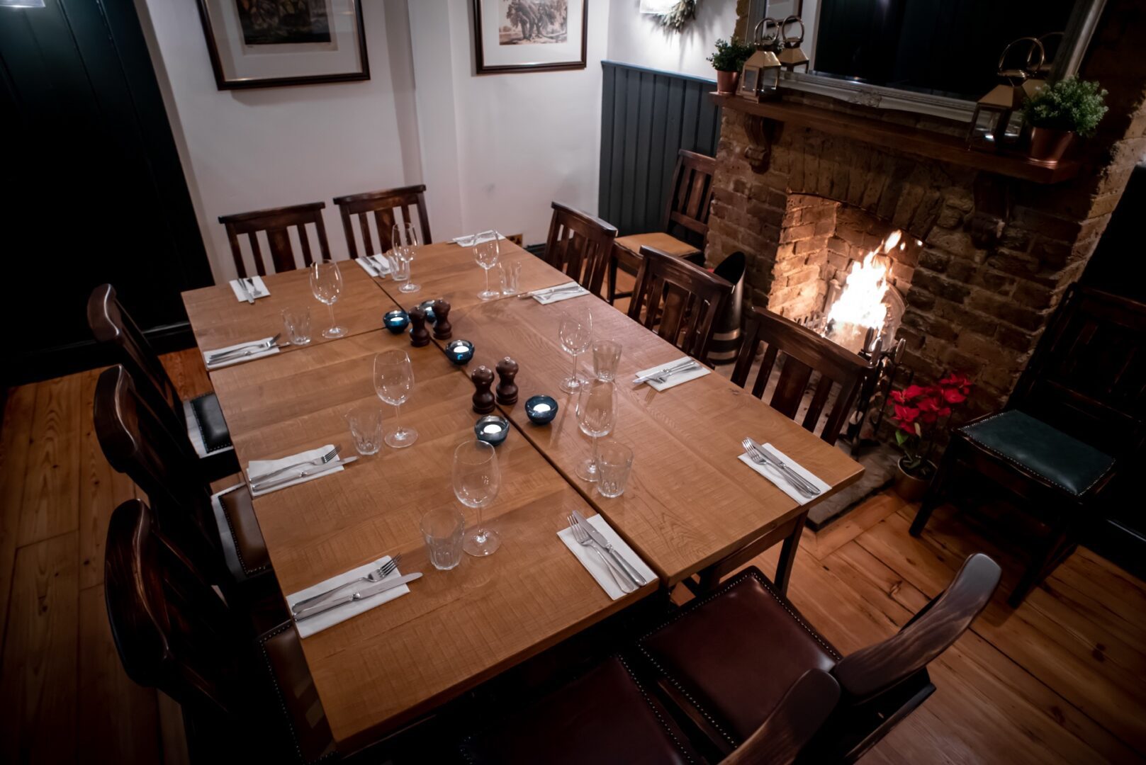 Cozy dining table by fireplace in Snug Area, ideal for private events and networking dinners.