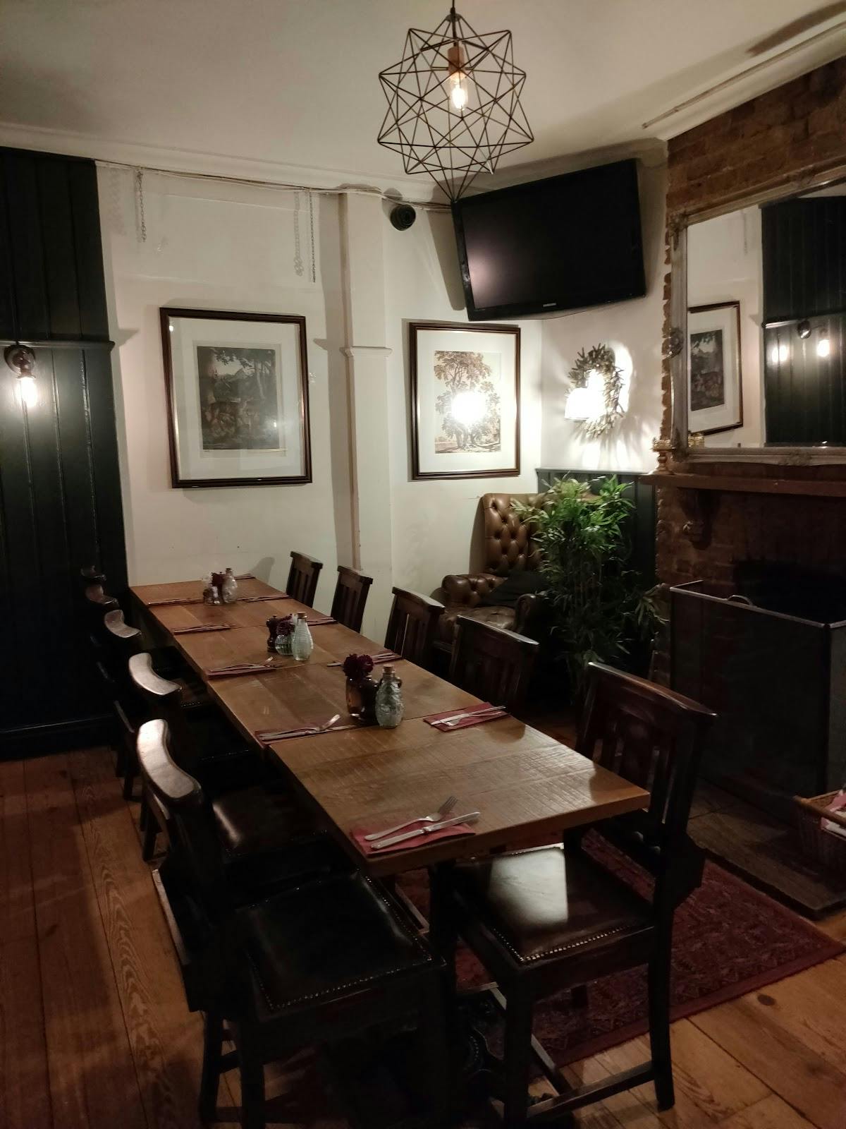 Cozy dining space with wooden table for intimate meetings at The Angel & Crown.