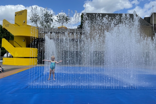 Vibrant community center with playful water fountain for summer family events.
