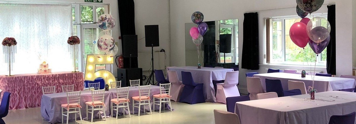 Vibrant birthday party setup at Troy Hall with colorful balloons and a "5" sign.