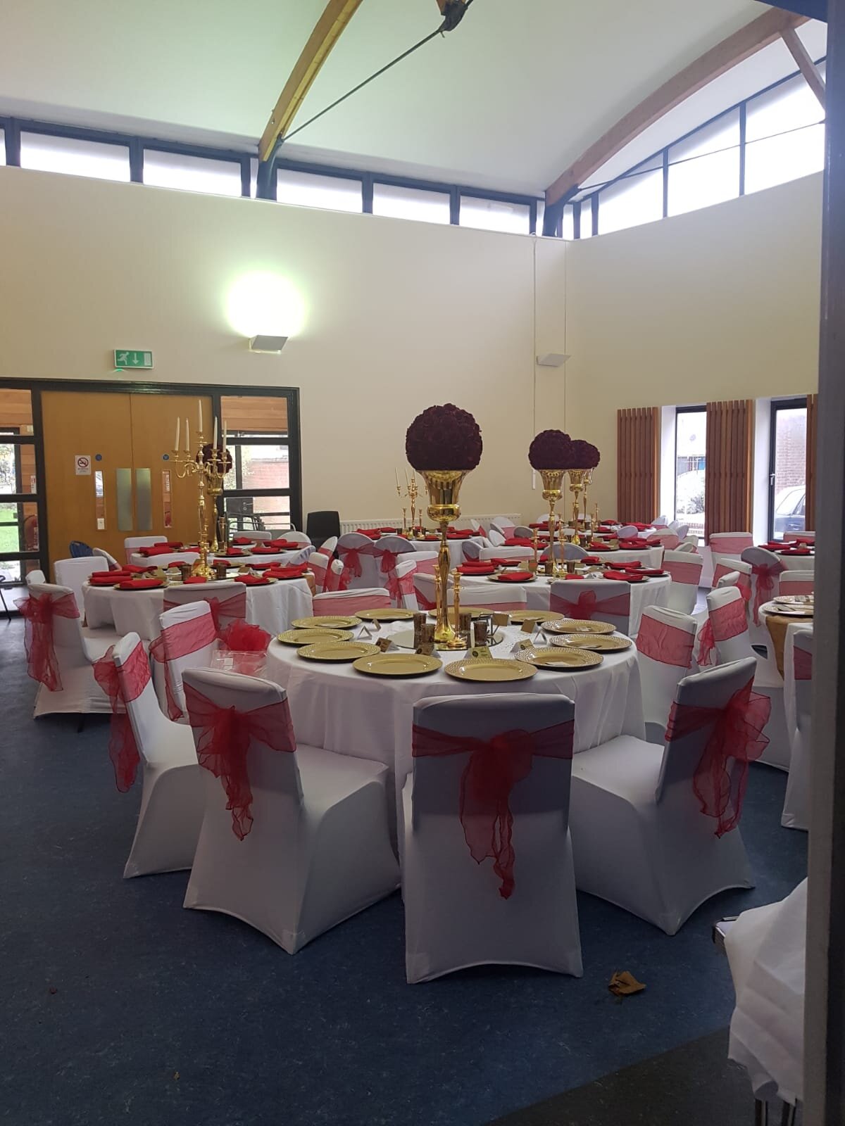 Elegant event space at Troy Hall, featuring round tables with red accents for weddings.