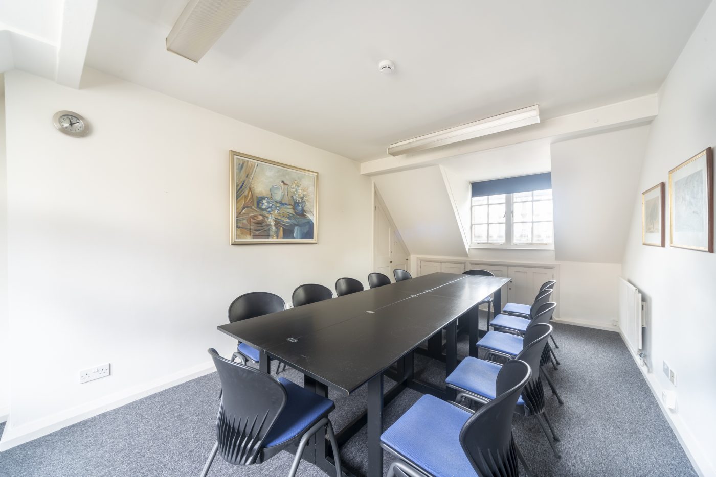 Well-lit Hackney Venues meeting room with black table for strategic planning events.