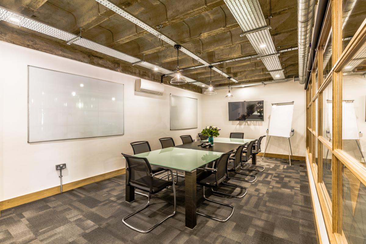 Modern meeting room in Hackney Venues with glass table for productive sessions.
