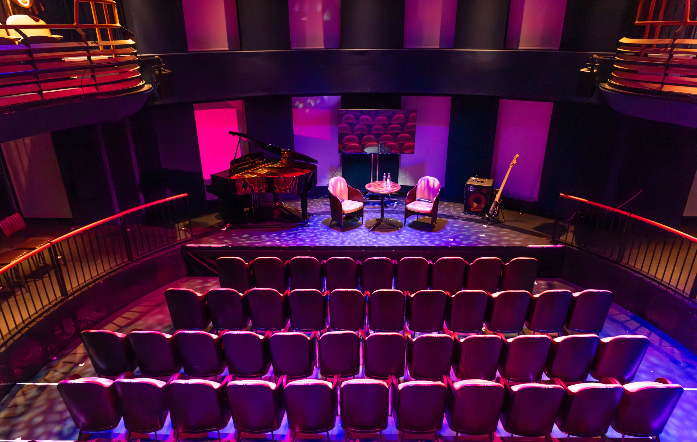 Intimate Underbelly Boulevard auditorium set for panel discussion or acoustic performance.