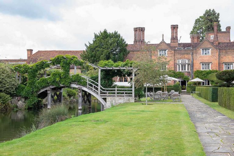Magnolia Lawn at Great Fosters: scenic venue with bridge, ideal for weddings and retreats.