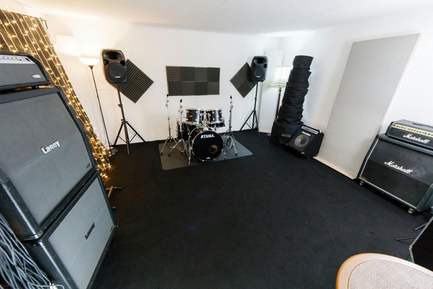 Rehearsal studio with sound equipment, ideal for live music events and workshops.