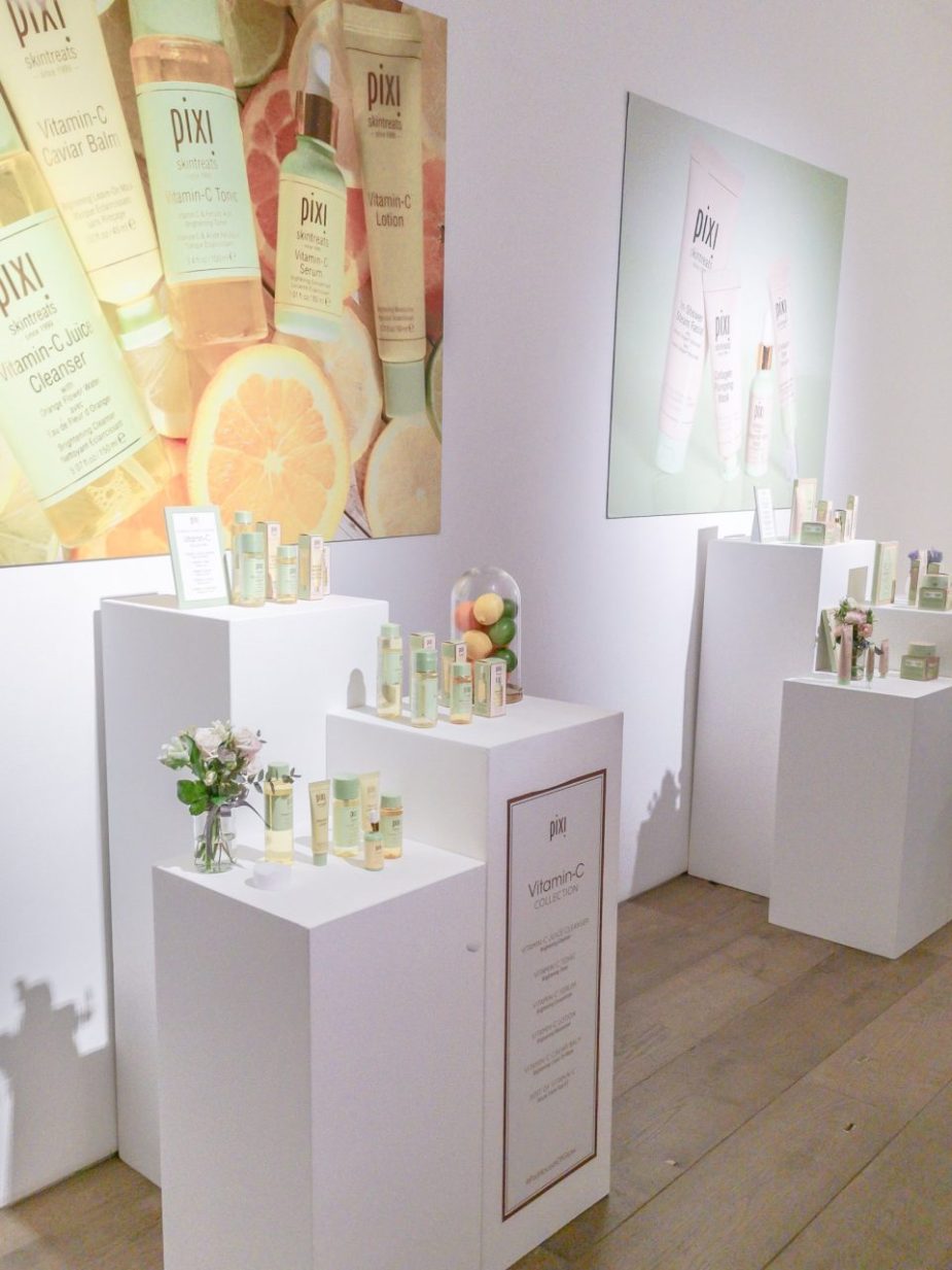 Makepeace Studio skincare event display with organized bottles and vibrant backdrop.