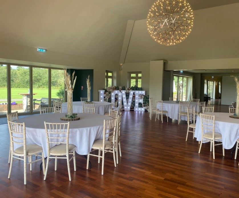 Elegant event space at Arkley Golf Club with round tables, ideal for weddings.