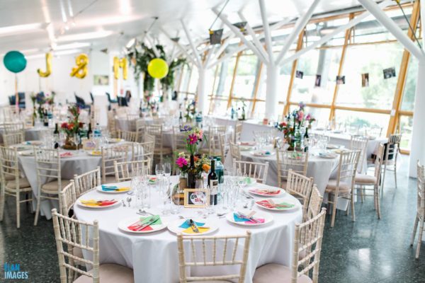 Contemporary glass-walled event space with elegant tables for celebrations and corporate gatherings.