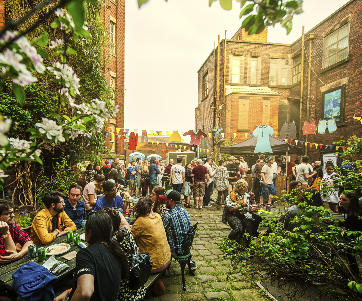 Vibrant outdoor networking event at New Islington Mill with colorful decorations.