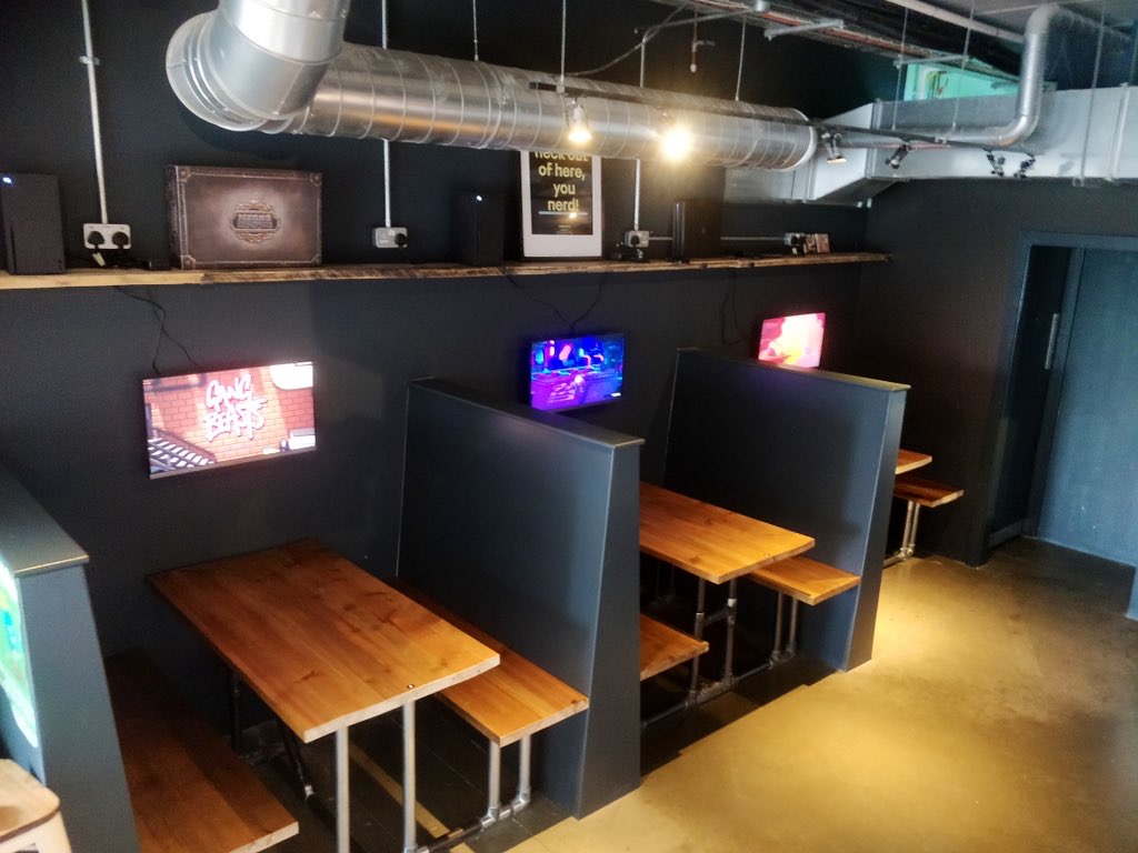 Modern meeting space at Loading Bar Peckham with wooden tables and screens for events.