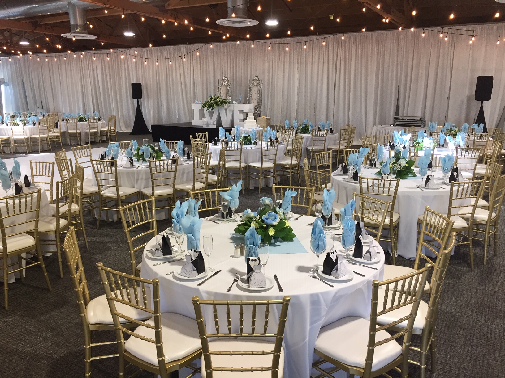 Elegant banquet hall with aqua napkins, perfect for weddings and formal events.
