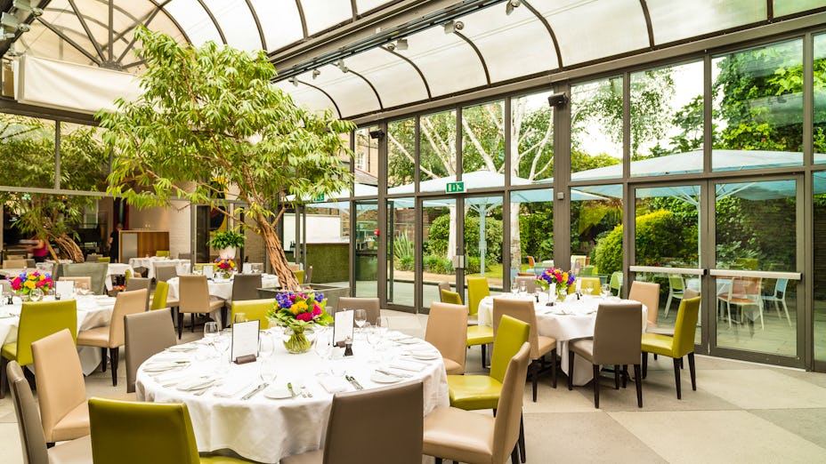 Elegant event space with round tables and greenery for formal gatherings and receptions.