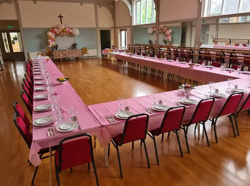 St. Peter's Hall event space with U-shaped tables, pink linens, and elegant decor.