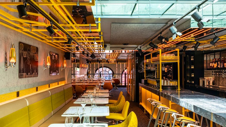 Vibrant Private Hire event space with yellow accents, ideal for networking and meetings.