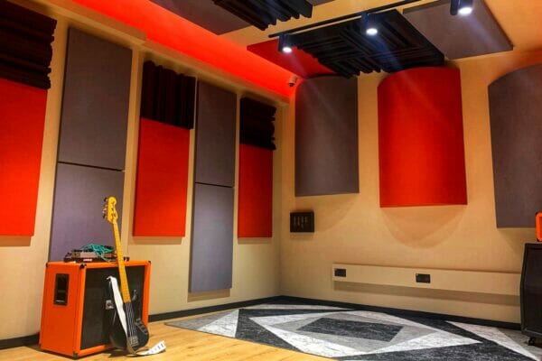 Modern recording studio with orange soundproofing panels for music production workshops.