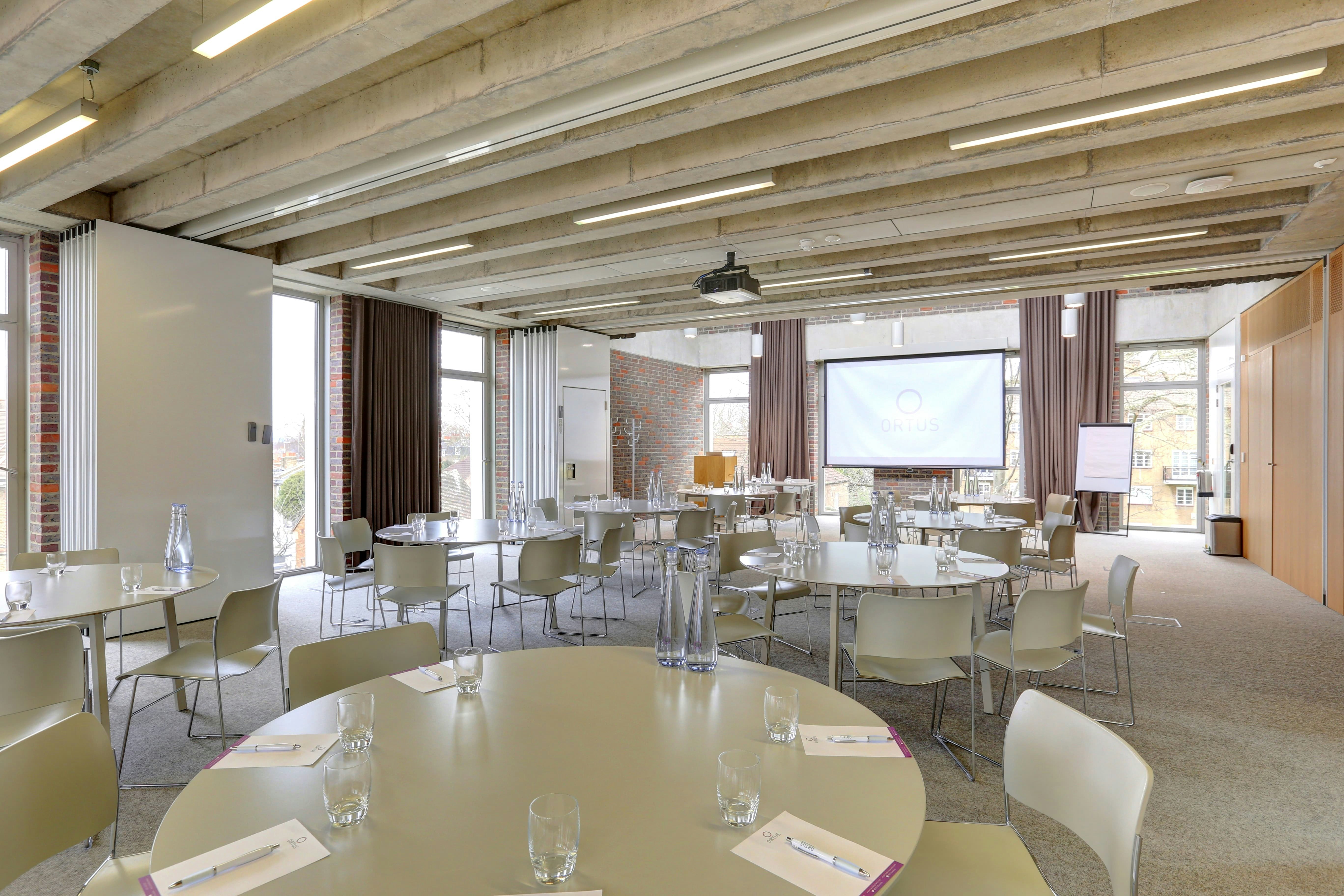 Versatile meeting room with round tables and natural light for productive events.