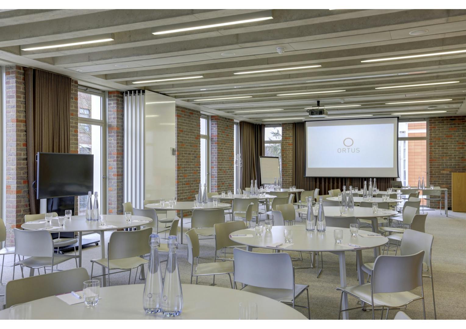 Modern meeting room with round tables, perfect for workshops and corporate events.