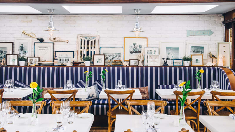 Stylish dining room with striped seating, perfect for corporate events and intimate gatherings.