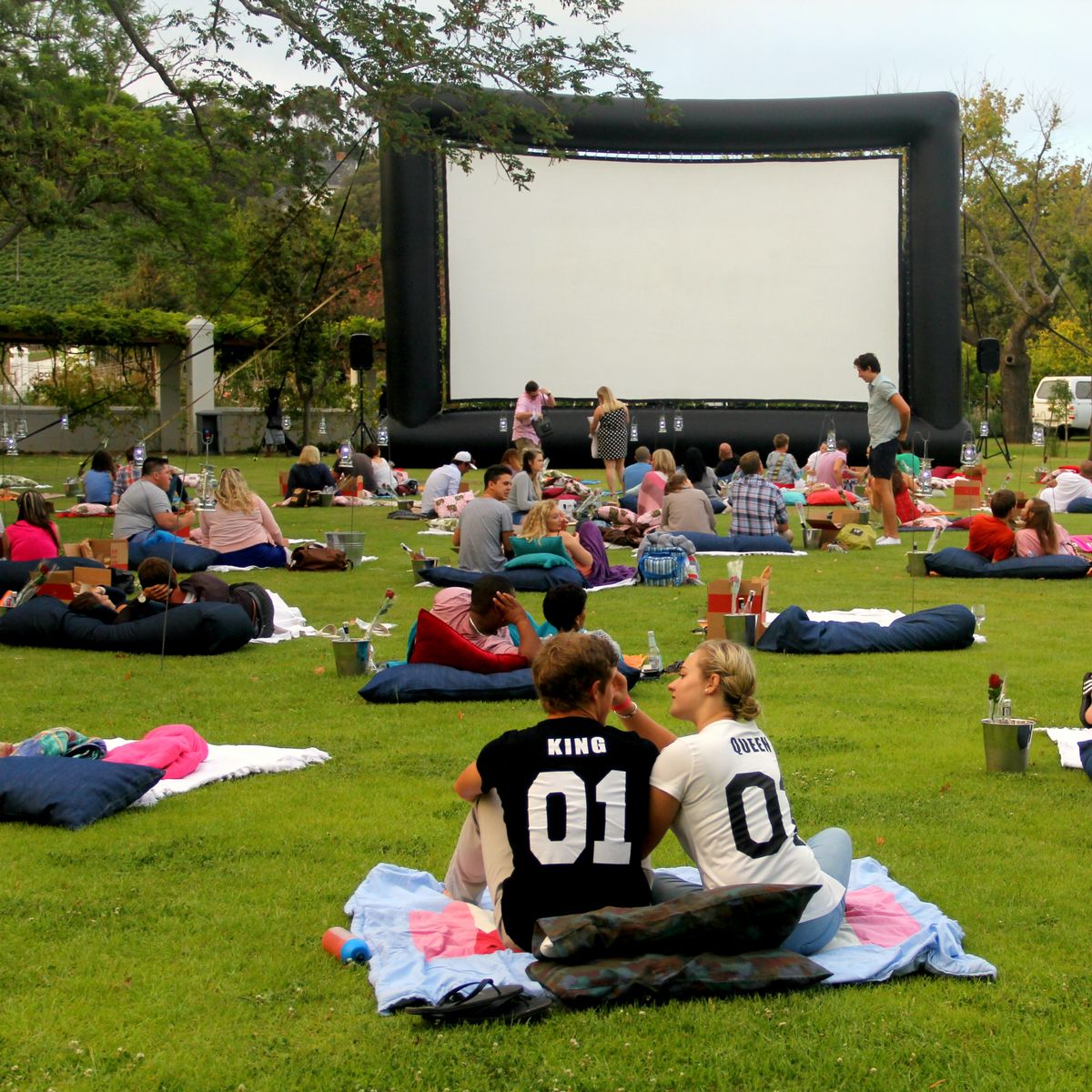 Outdoor cinema event with large inflatable screen and picnic seating in Berkshire.